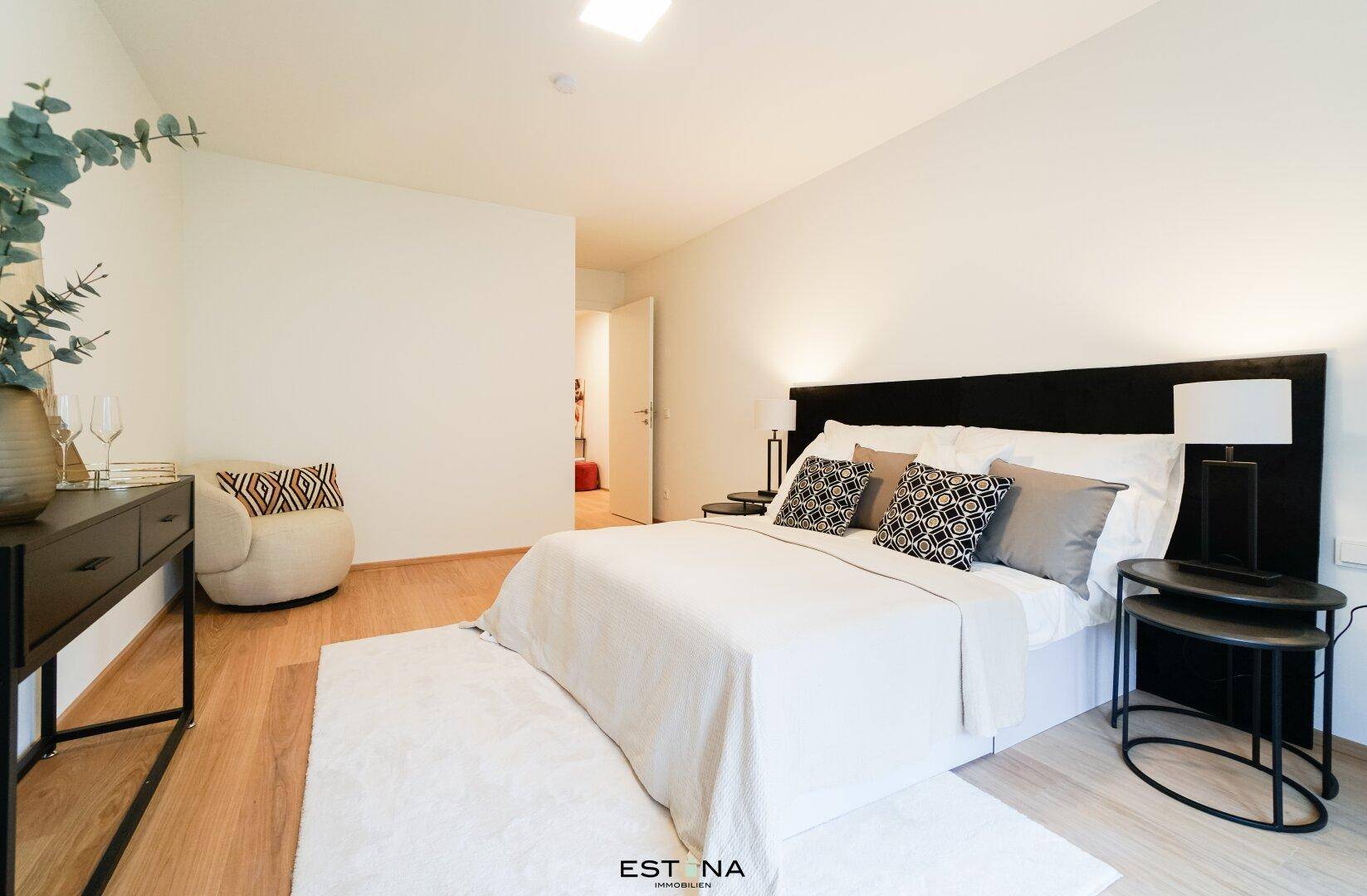 Modern eingerichtetes Schlafzimmer mit Holzboden und schlichtem Design, ideal zum Entspannen.
