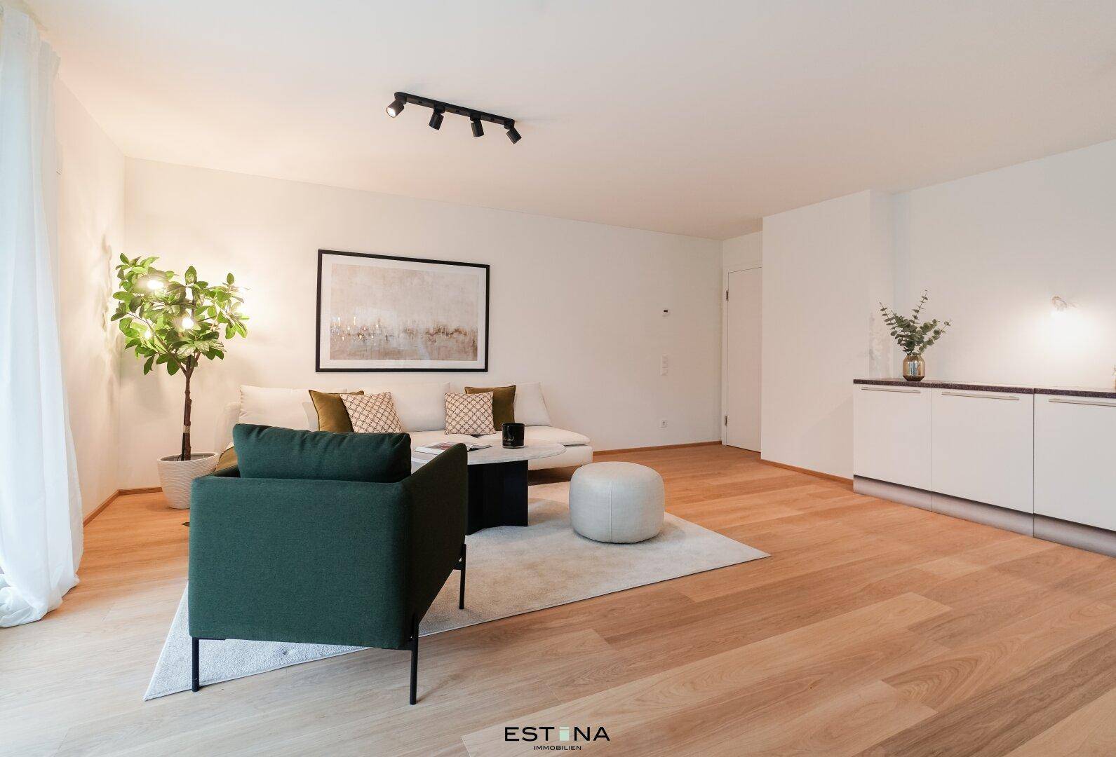 Gemütlicher Wohnbereich mit bequemer Couch, Sessel und Holzboden in hellem Ambiente.