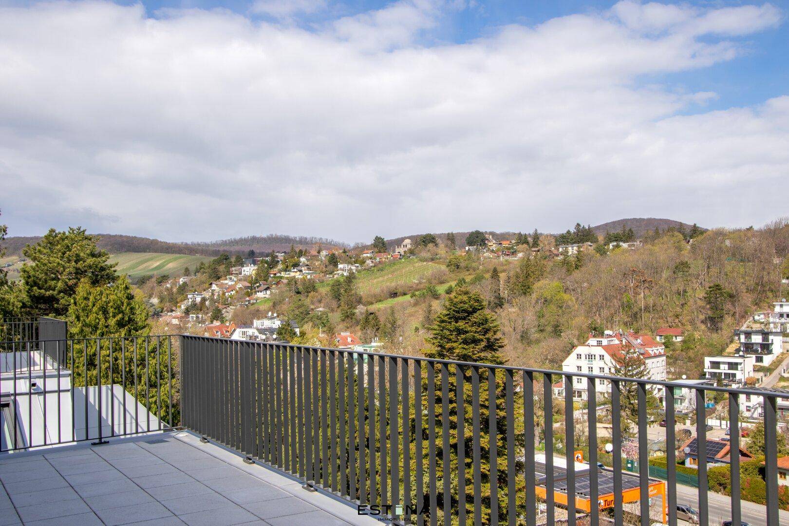 Balkon mit weitem Blick auf die hügelige Landschaft und die umliegenden Häuser.