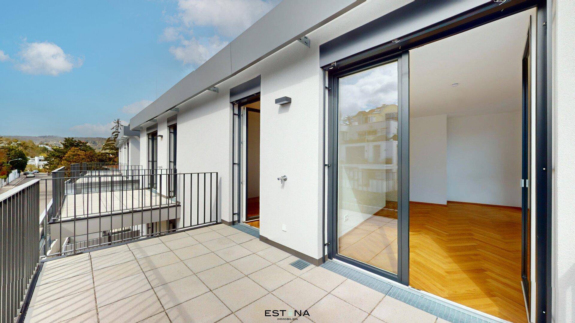Geräumiger Balkon mit Fliesenboden und Blick auf die Umgebung, ideal für Entspannung im Freien.