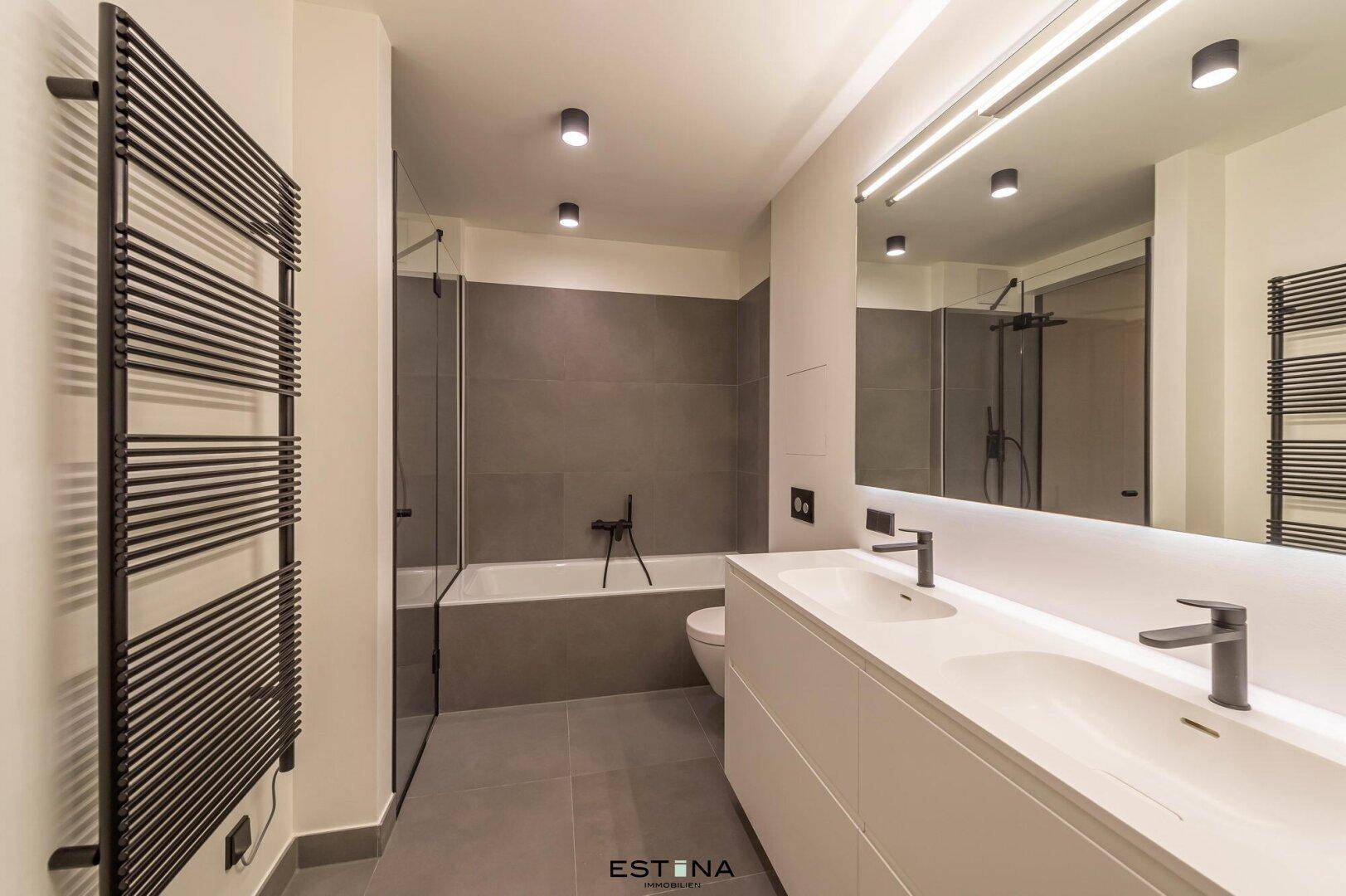 Geräumiges modernes Badezimmer mit Doppelwaschbecken, Badewanne und Dusche.