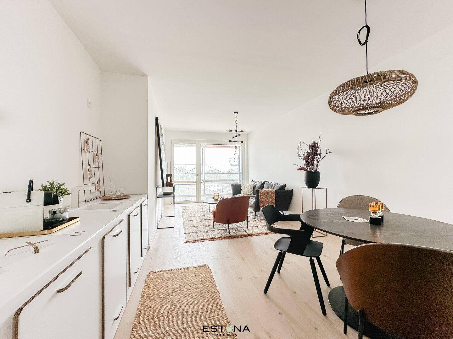 Lichtdurchfluteter offener Wohn- und Essbereich mit Zugang zum Balkon und moderner Einrichtung.