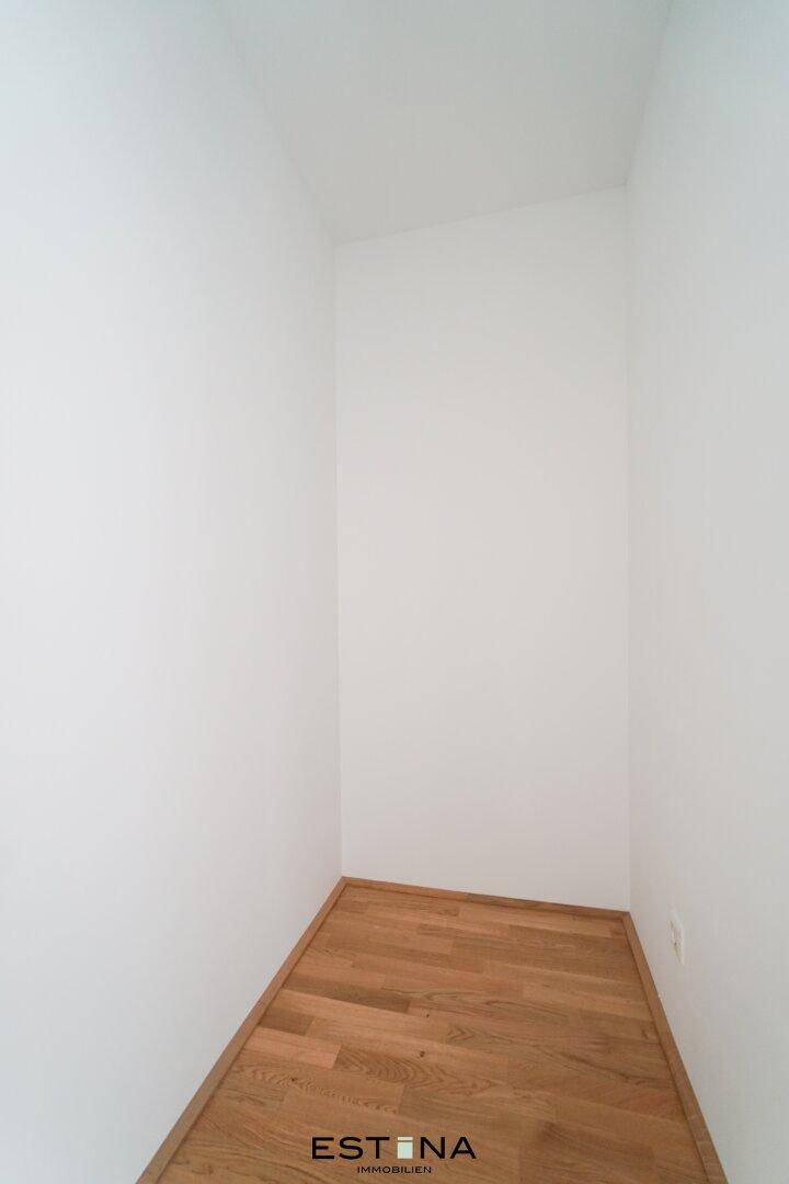 Praktischer Abstellraum mit Holzboden und weißen Wänden, ideal für zusätzlichen Stauraum.
