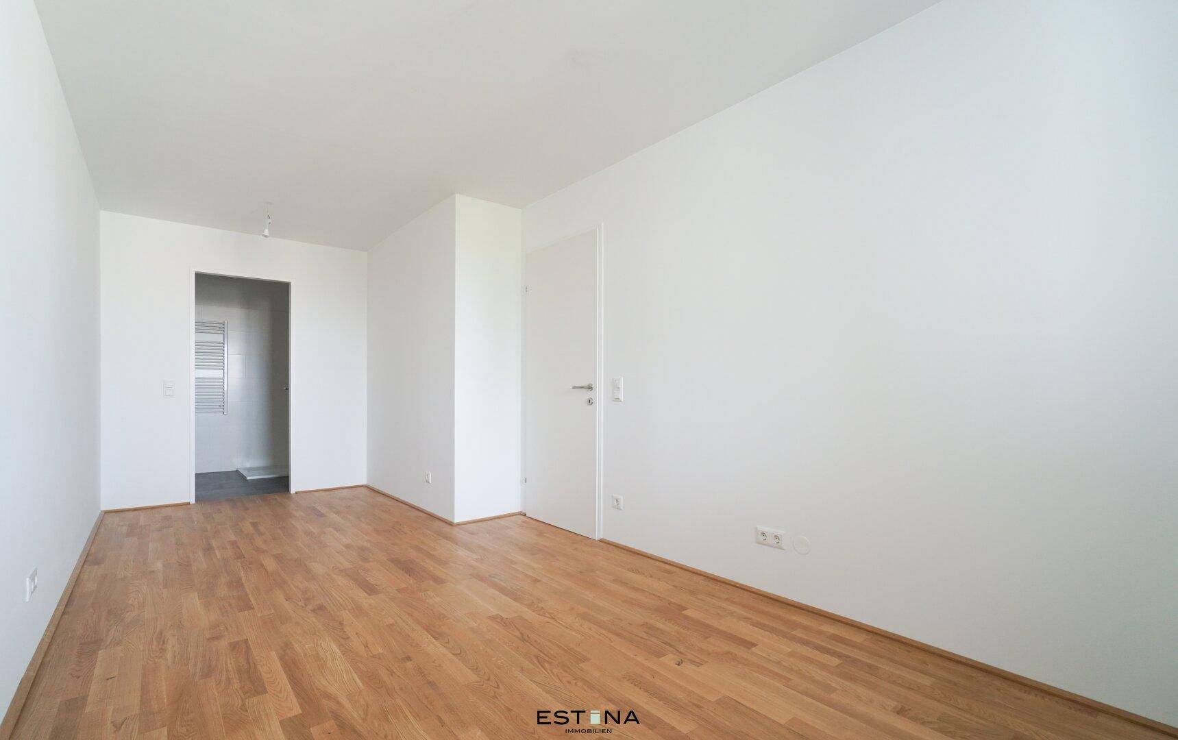 Heller, unmöblierter Raum mit Holzboden und weiß gestrichenen Wänden, ideal für flexible Nutzung.