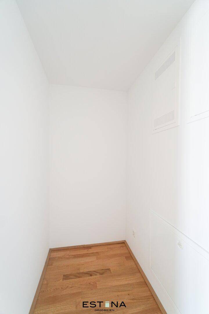 Kleiner, heller Abstellraum mit Holzboden und weißen Wänden, ideal für zusätzlichen Stauraum.