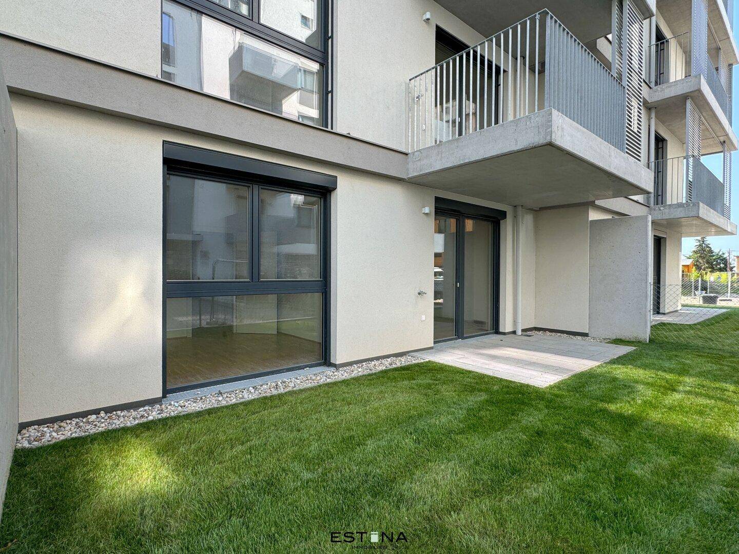 Erdgeschosswohnung mit privatem Gartenbereich und Terrasse, umgeben von moderner Architektur.