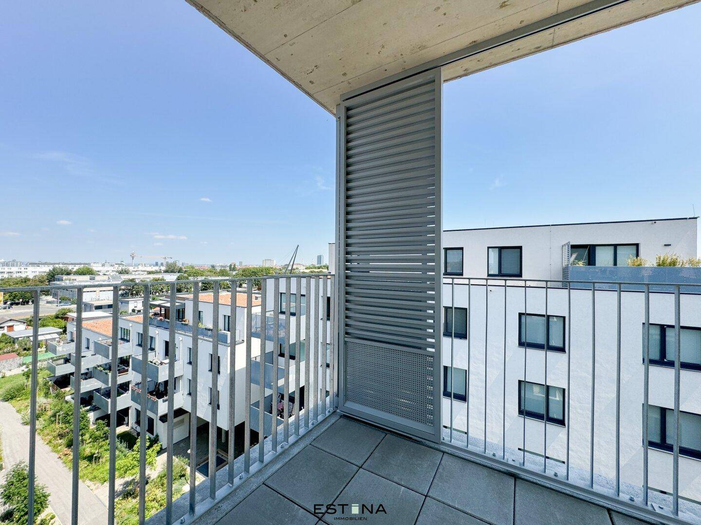 Moderner Balkon mit Metallgeländer und Blick auf die umliegende Wohnbebauung.