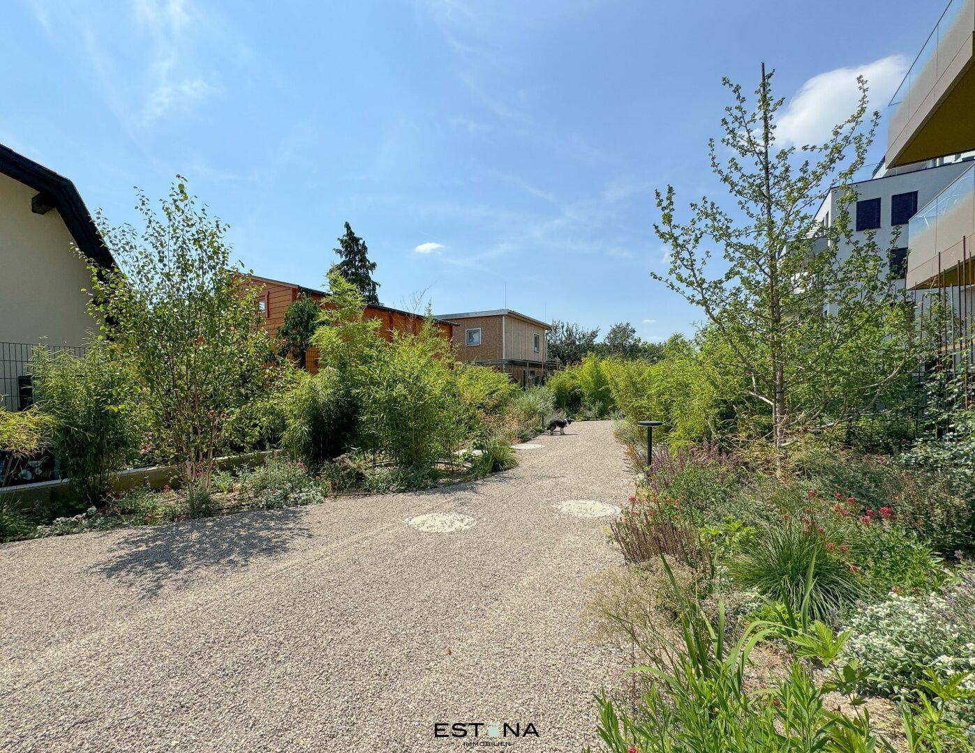 Gepflegter Gemeinschaftsgarten mit Kieswegen und vielfältiger Bepflanzung, ideal zum Entspannen.