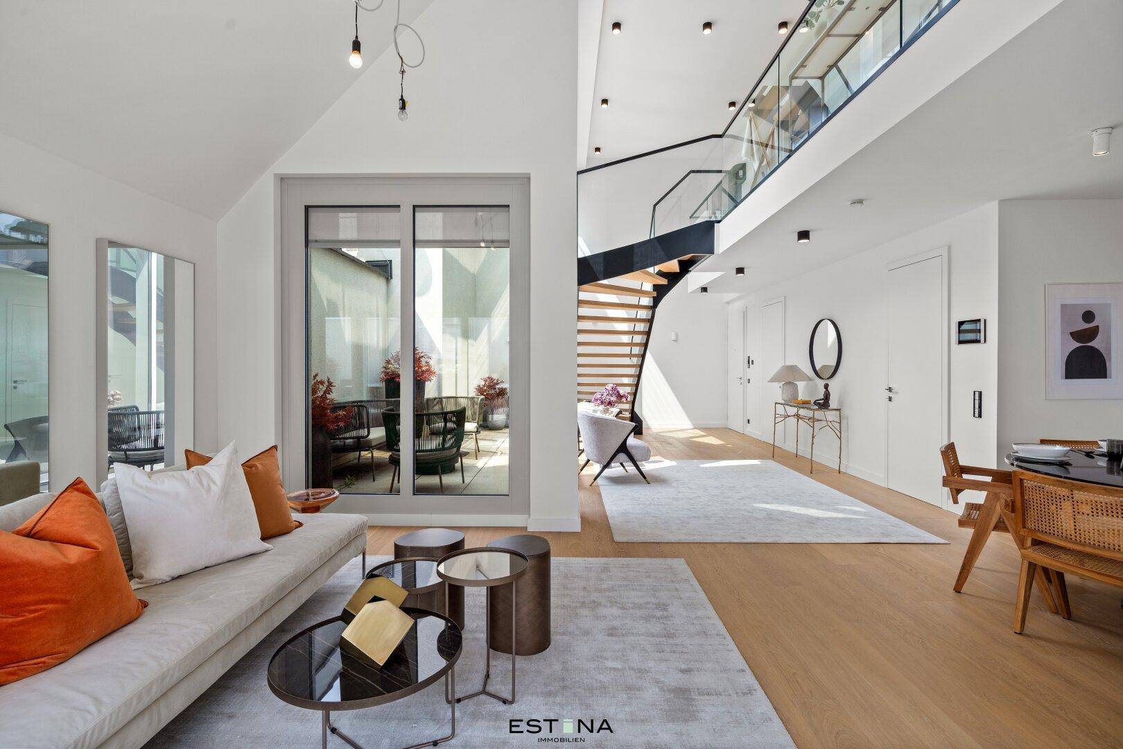 Geräumiges Wohnzimmer mit hohen Decken, moderner Einrichtung und Zugang zu einem Außenbereich.
