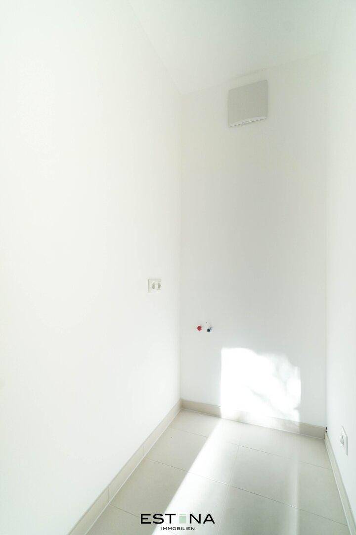 Kleiner, gefliester Hauswirtschaftsraum mit Anschlüssen für Waschmaschine und Trockner.