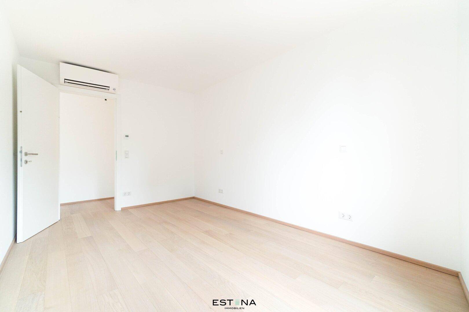 Helles Schlafzimmer mit Parkettboden und Klimaanlage, ideal für erholsame Nächte.