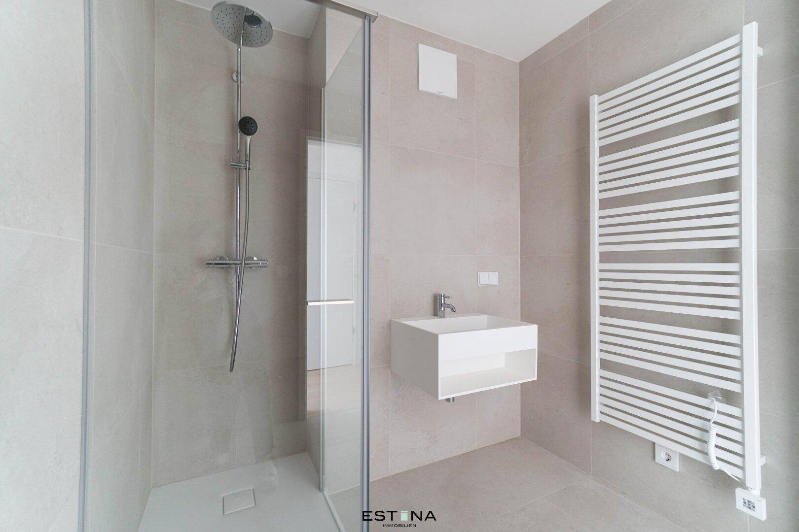 Modernes Badezimmer mit begehbarer Dusche, Wandwaschbecken und beheiztem Handtuchhalter.