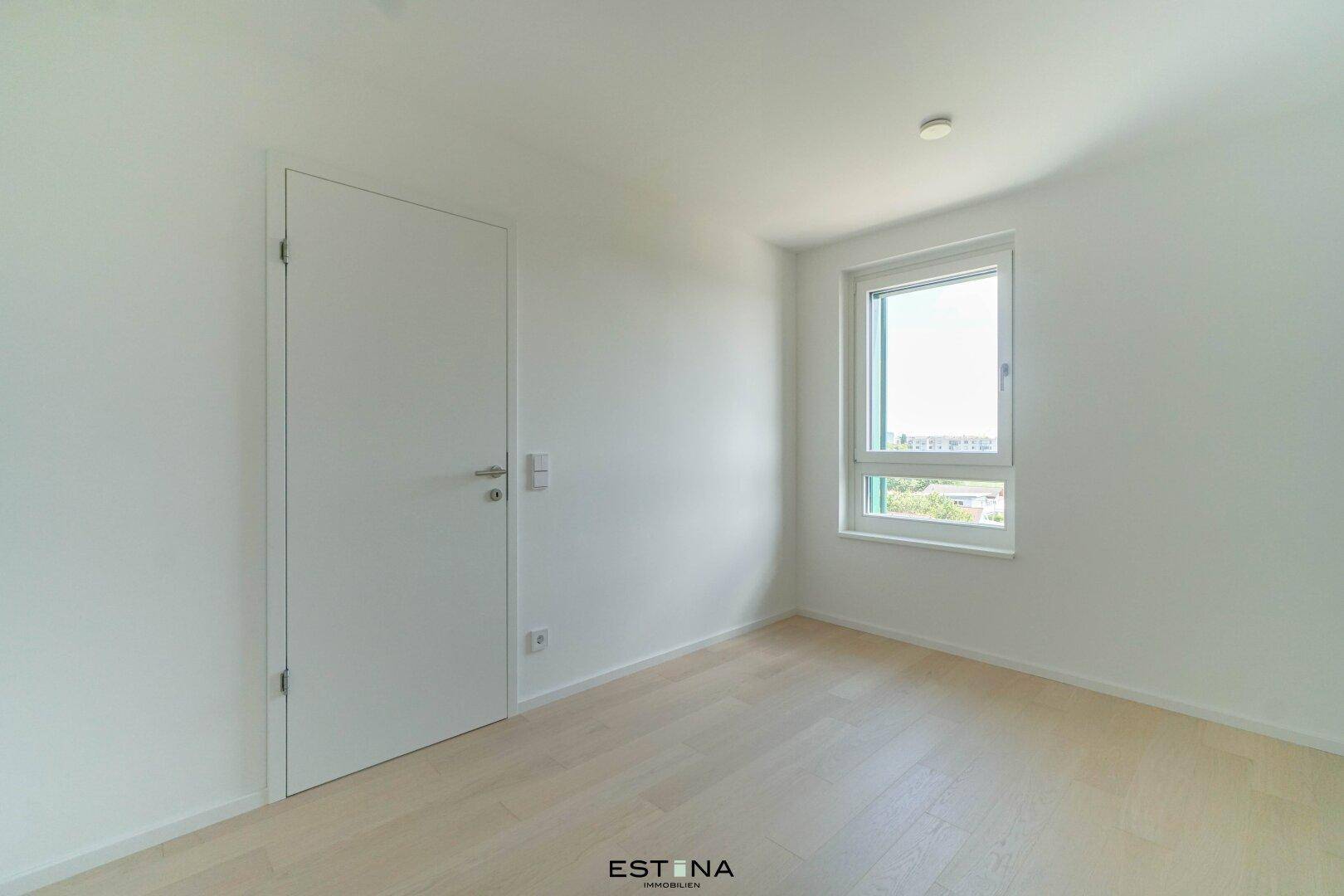 Ruhiges Zimmer mit hellem Holzboden und einem Fenster, ideal als Schlaf- oder Arbeitszimmer.