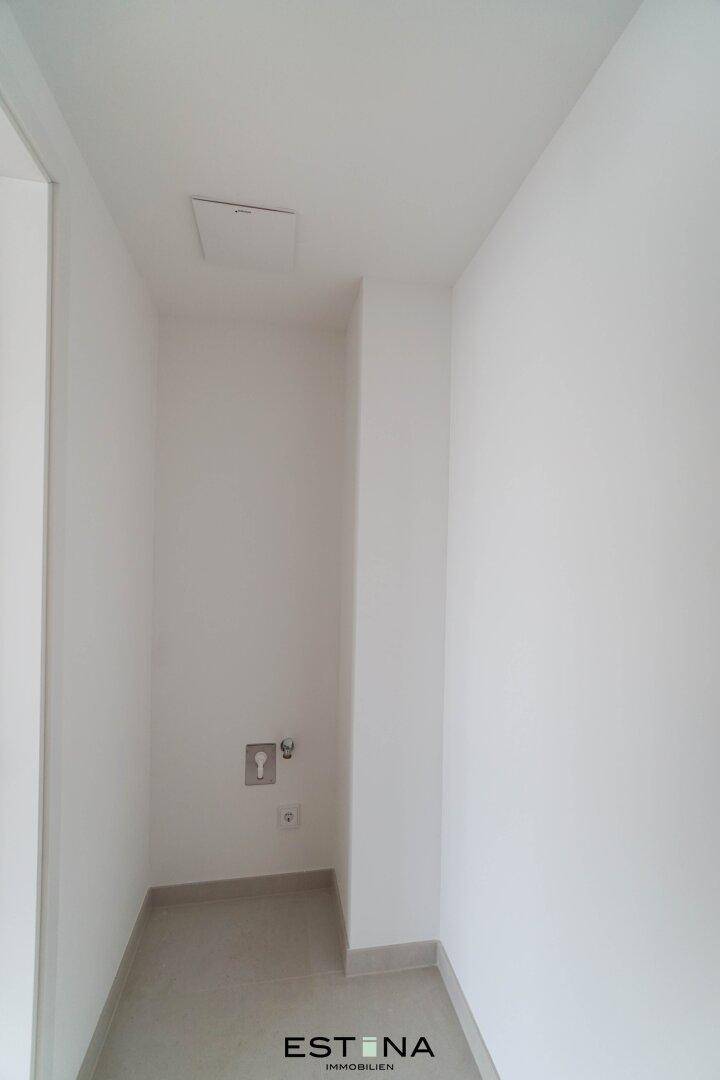 Praktischer Hauswirtschaftsraum mit Anschlüssen für Waschmaschine und Trockner, mit Fliesenboden.