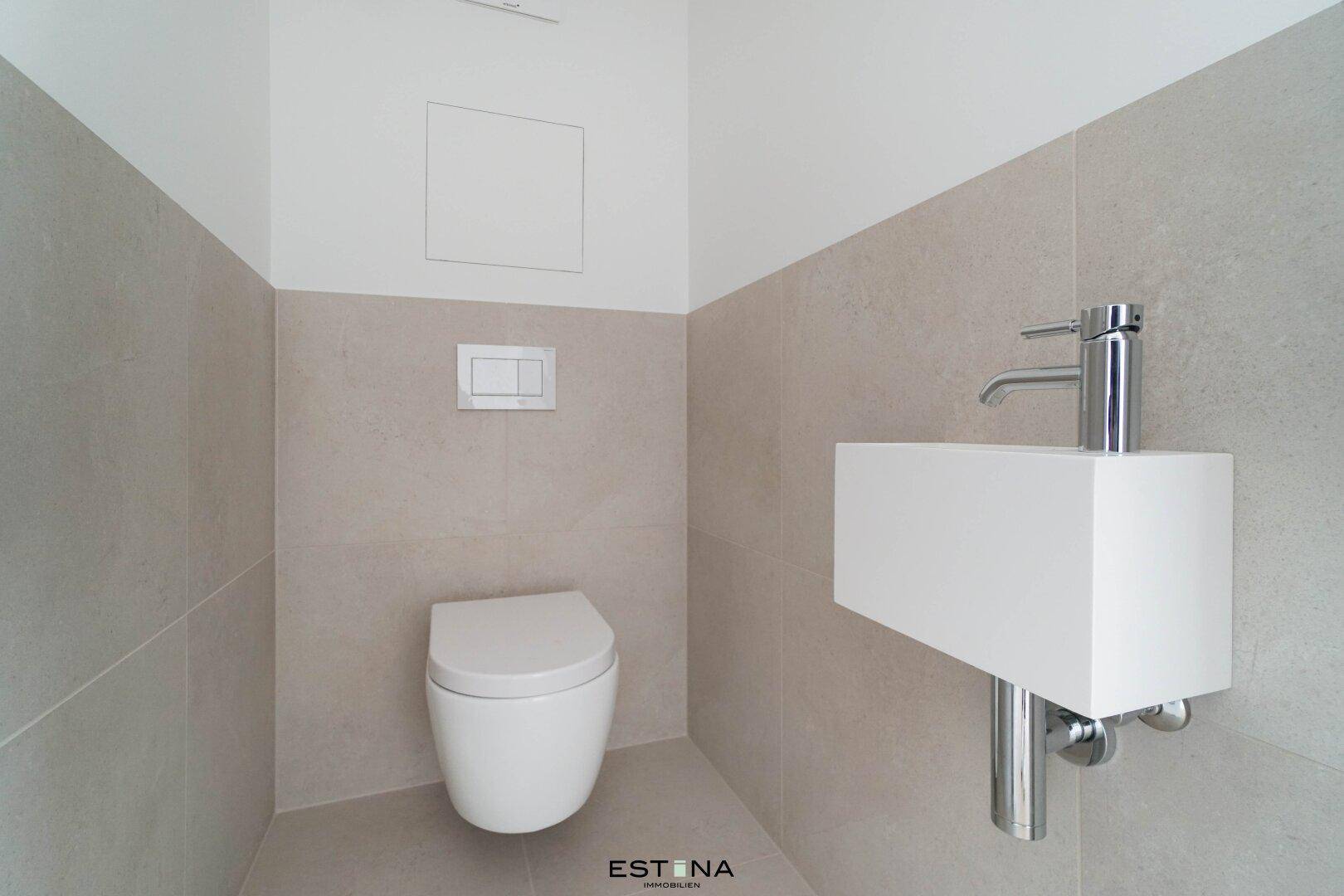 Modernes Gäste-WC mit wandhängender Toilette und kleinem Waschbecken.