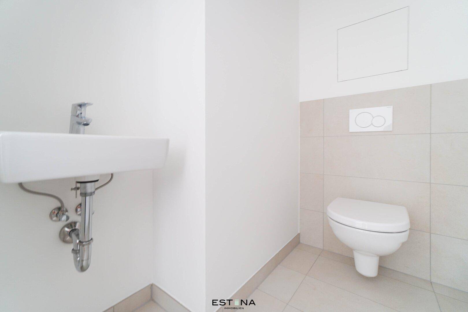 Funktionelles Gäste-WC mit wandhängender Toilette, kleinem Waschbecken und hellen Fliesen.
