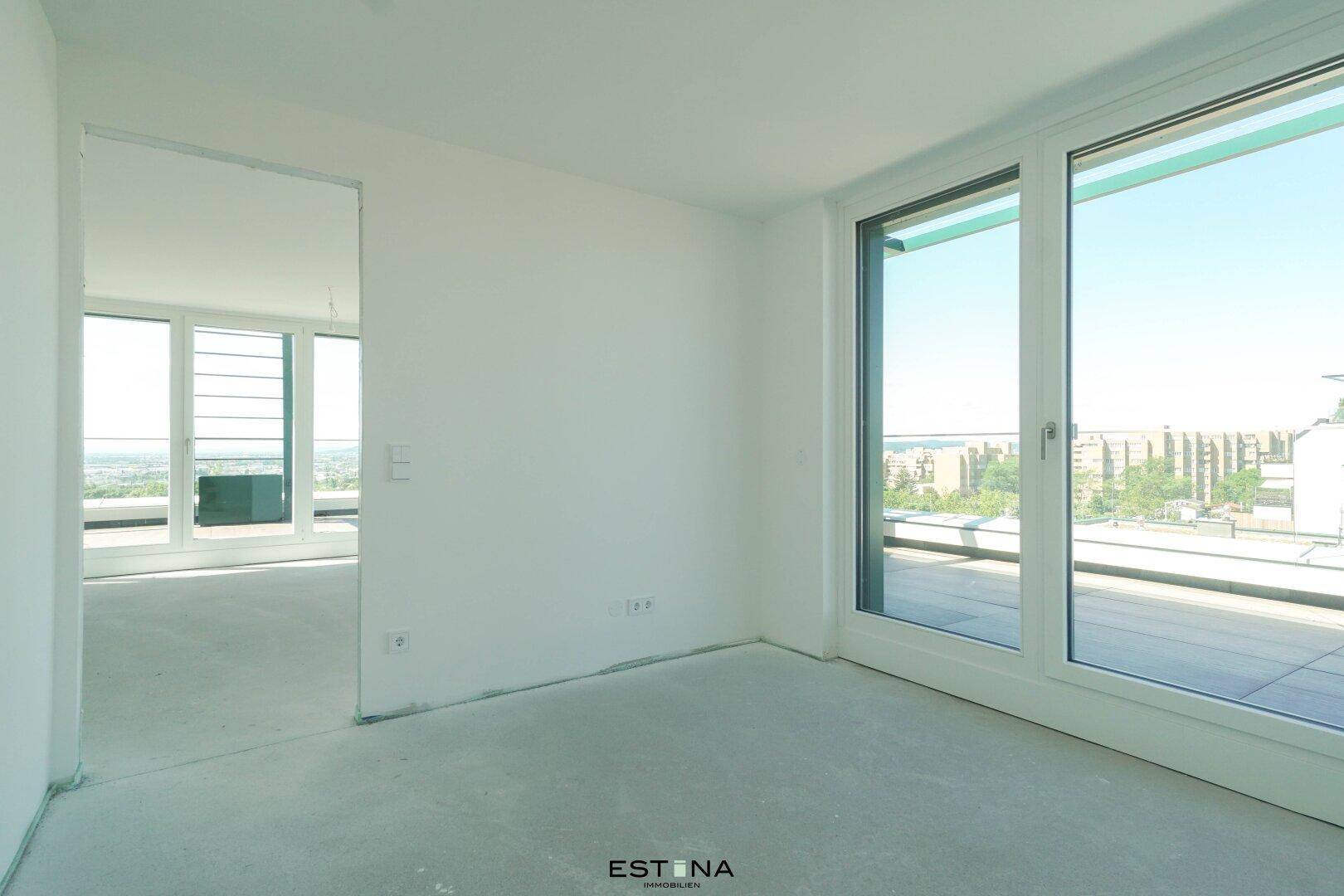 Unmöblierter Raum mit Zugang zur Terrasse und Blick auf die Umgebung.