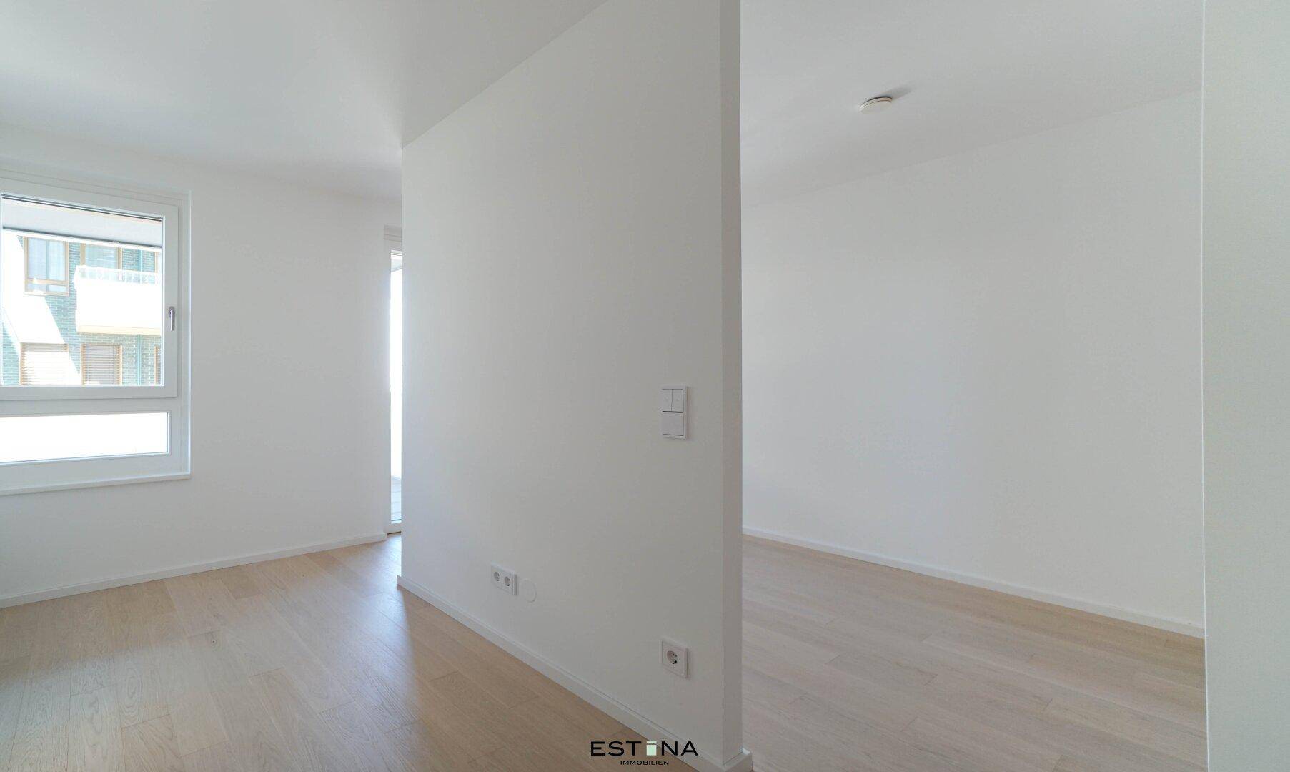 Lichtdurchfluteter, unmöblierter Raum mit hellen Wänden und modernem Holzfußboden.