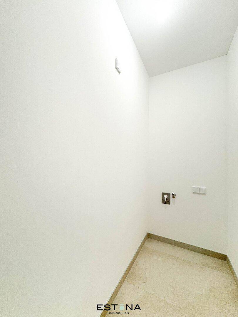 Kleiner Hauswirtschaftsraum mit Fliesenboden und Anschlüssen für eine Waschmaschine.