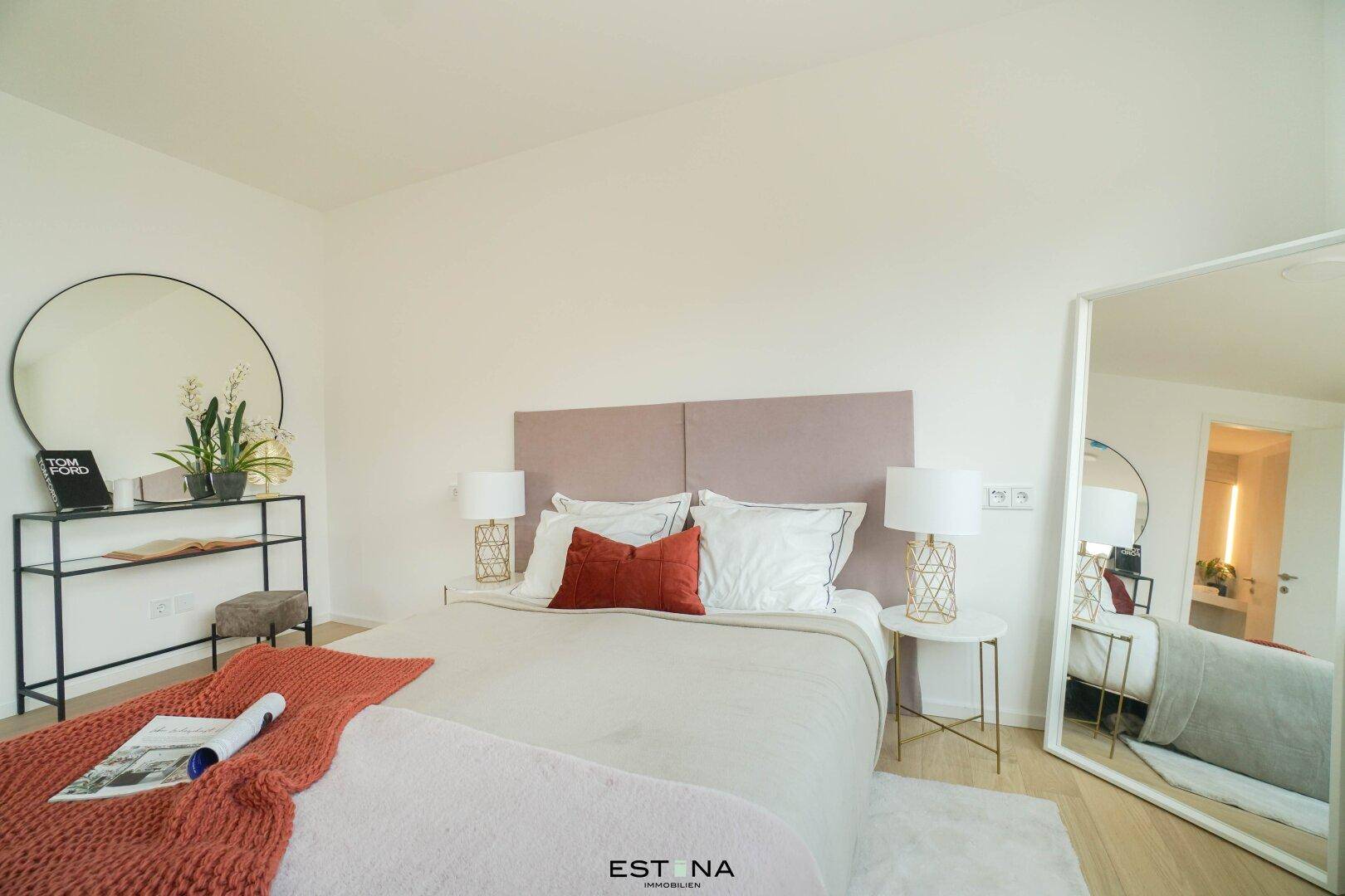 Modernes Schlafzimmer mit großem Bett, stilvollen Nachttischen und einem Ganzkörperspiegel.