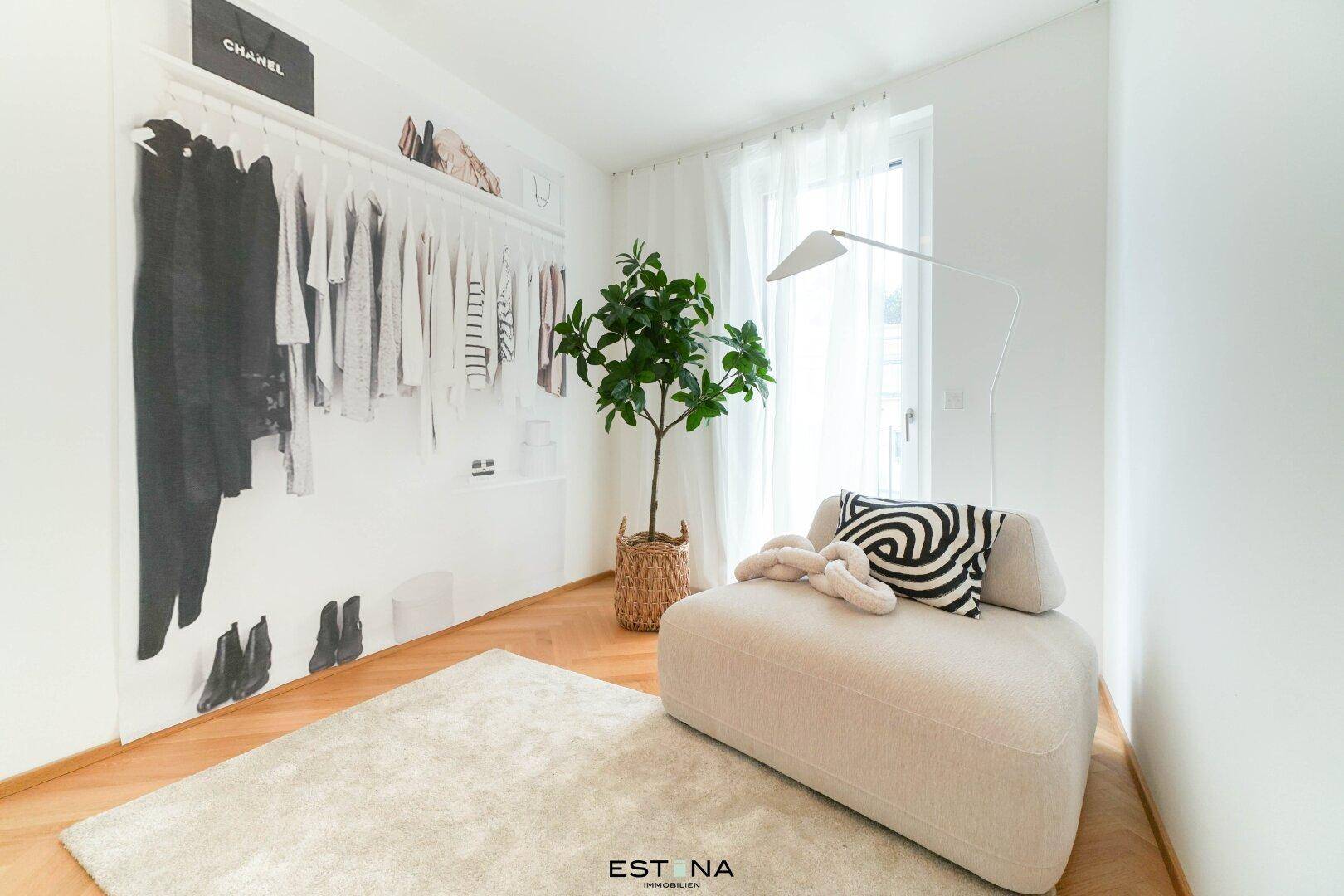 Heller Raum mit Chaiselongue, Pflanze und dekorativer Wandgestaltung, ideal als Ankleide.