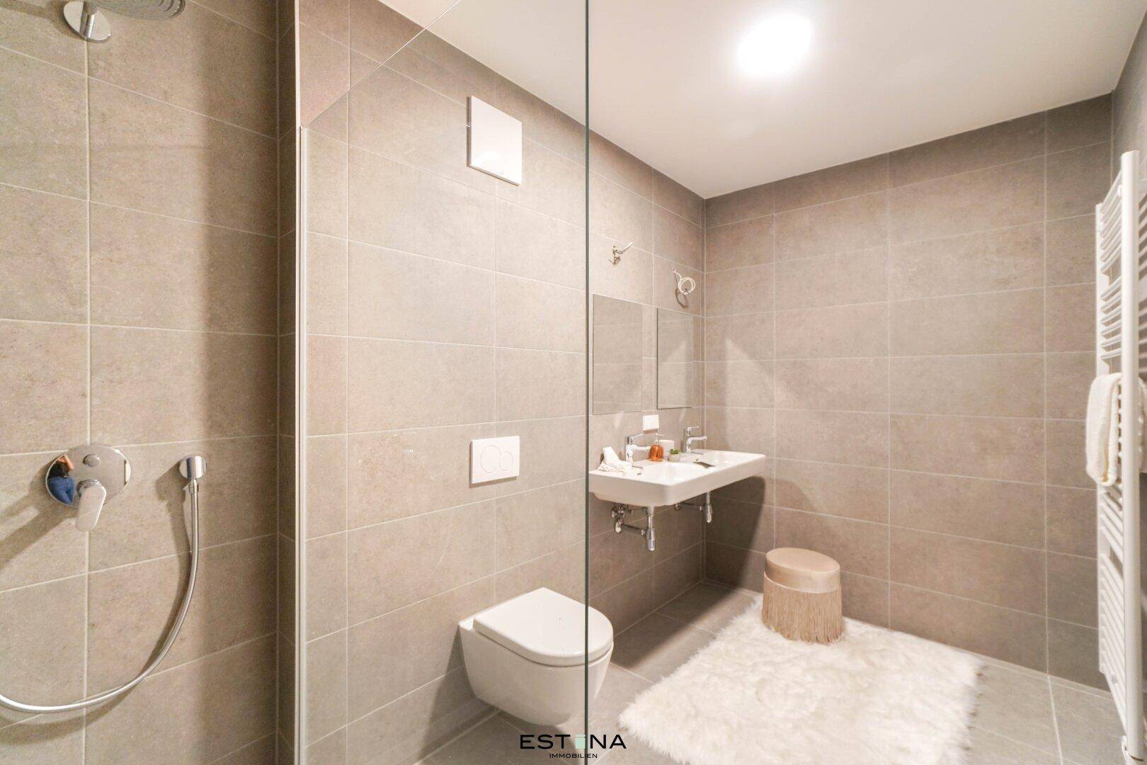 Modernes Badezimmer mit ebenerdiger Dusche, Wand-WC und Einzelwaschbecken.