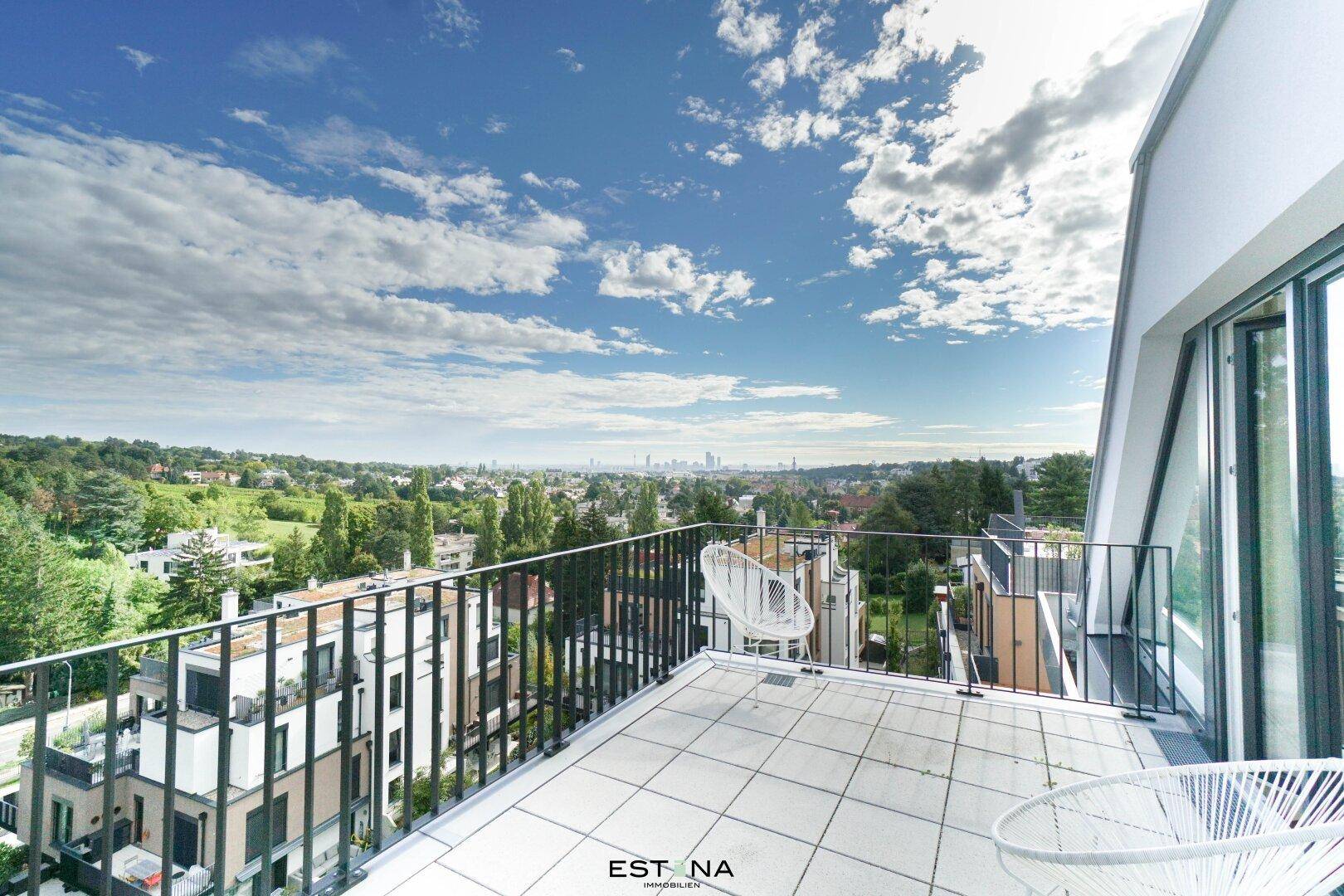Dachterrasse mit Geländer und weitem Panoramablick über die Stadt und grüne Umgebung.