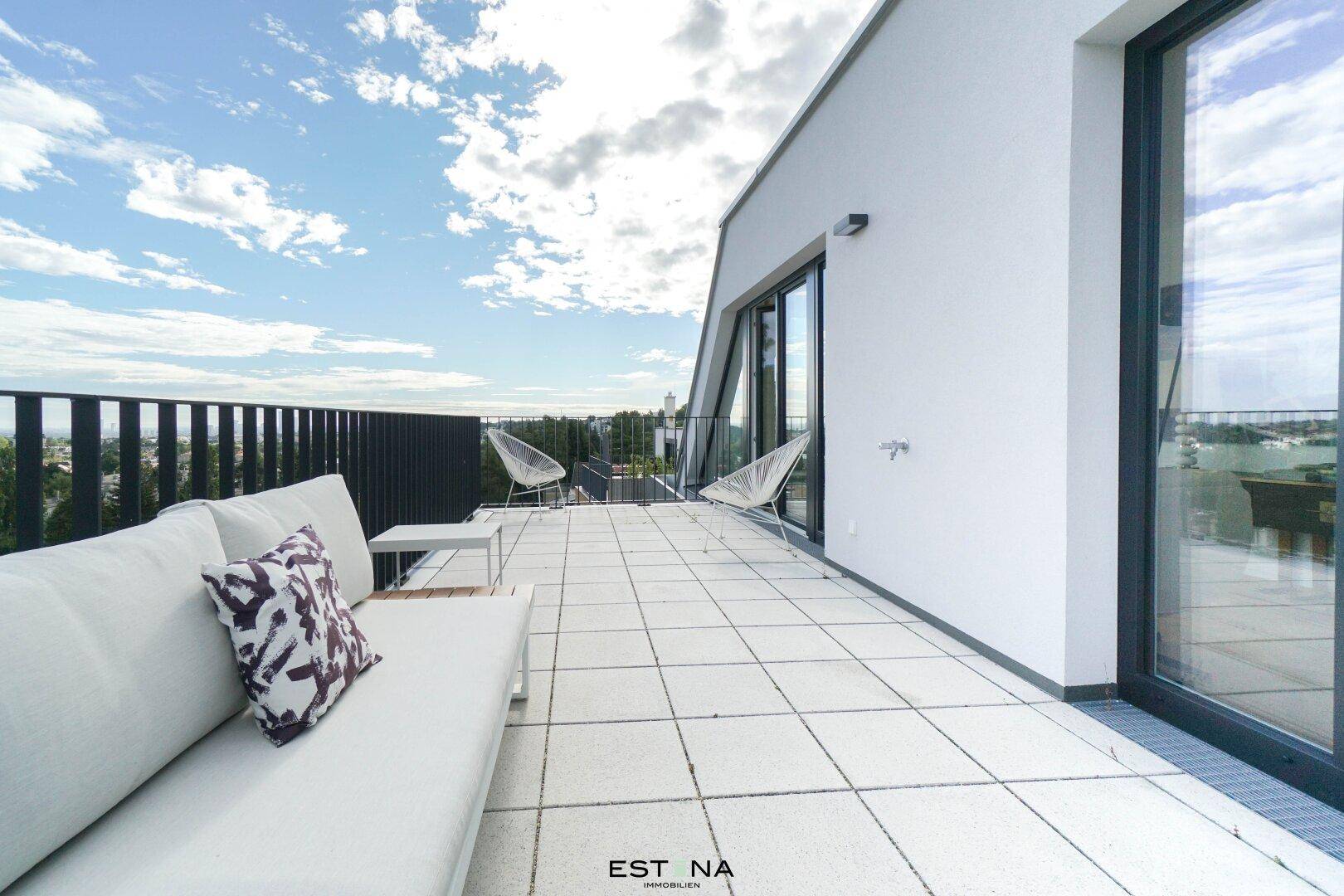 Geräumige Dachterrasse mit modernen Gartenmöbeln und weitem Blick in die Landschaft.