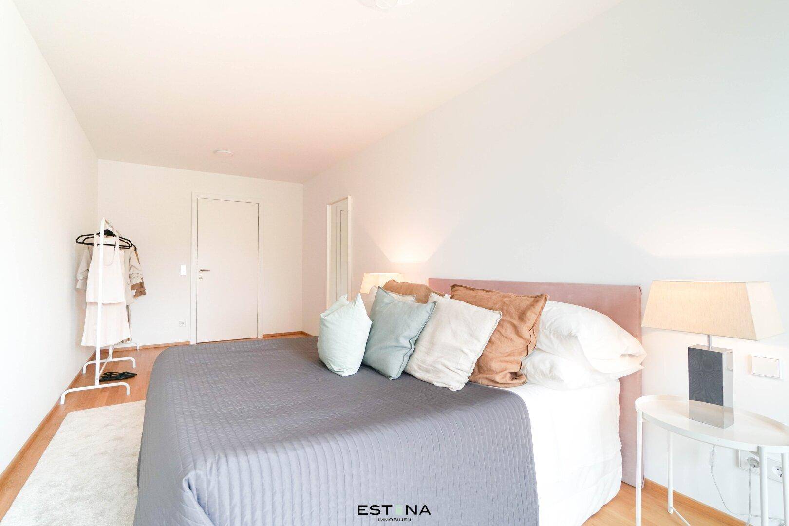 Geräumiges Schlafzimmer mit Doppelbett, Nachttischen und heller Einrichtung.