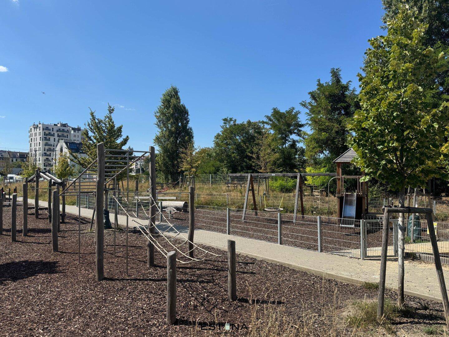 Großer öffentlicher Spielplatz mit vielfältigen Kletter- und Schaukelmöglichkeiten für Kinder.