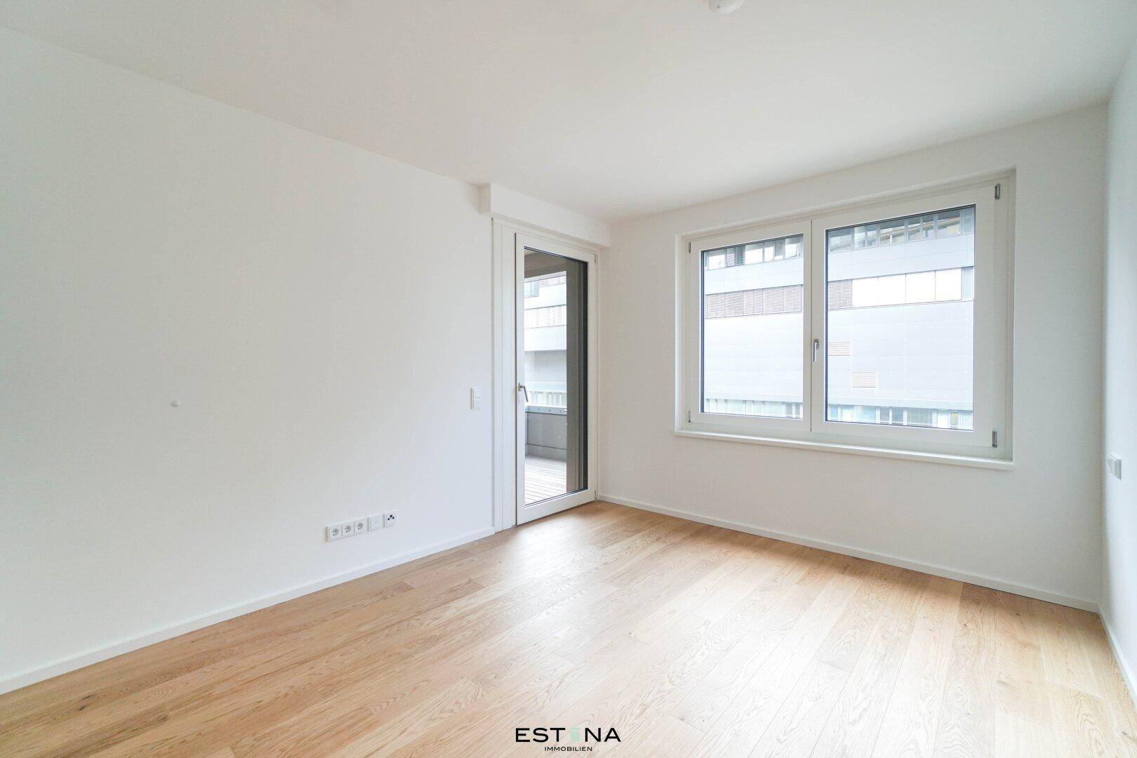 Leerer Raum mit hellem Holzboden und Fenster, bereit zur individuellen Gestaltung.