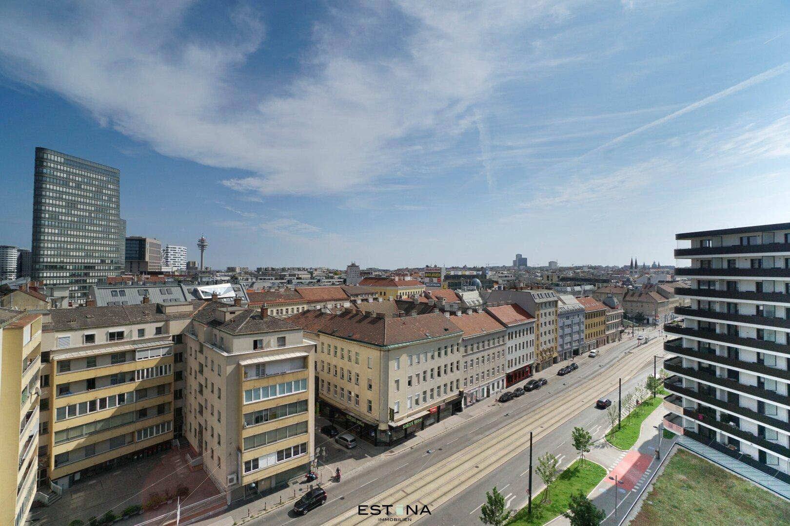Weitläufiger Stadtblick über Gebäude und Straßen mit klarem Himmel.