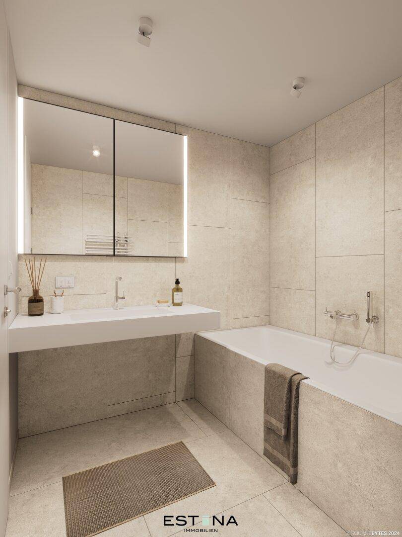 Modernes Badezimmer mit großer Badewanne, eleganten Fliesen und beleuchtetem Spiegelschrank.