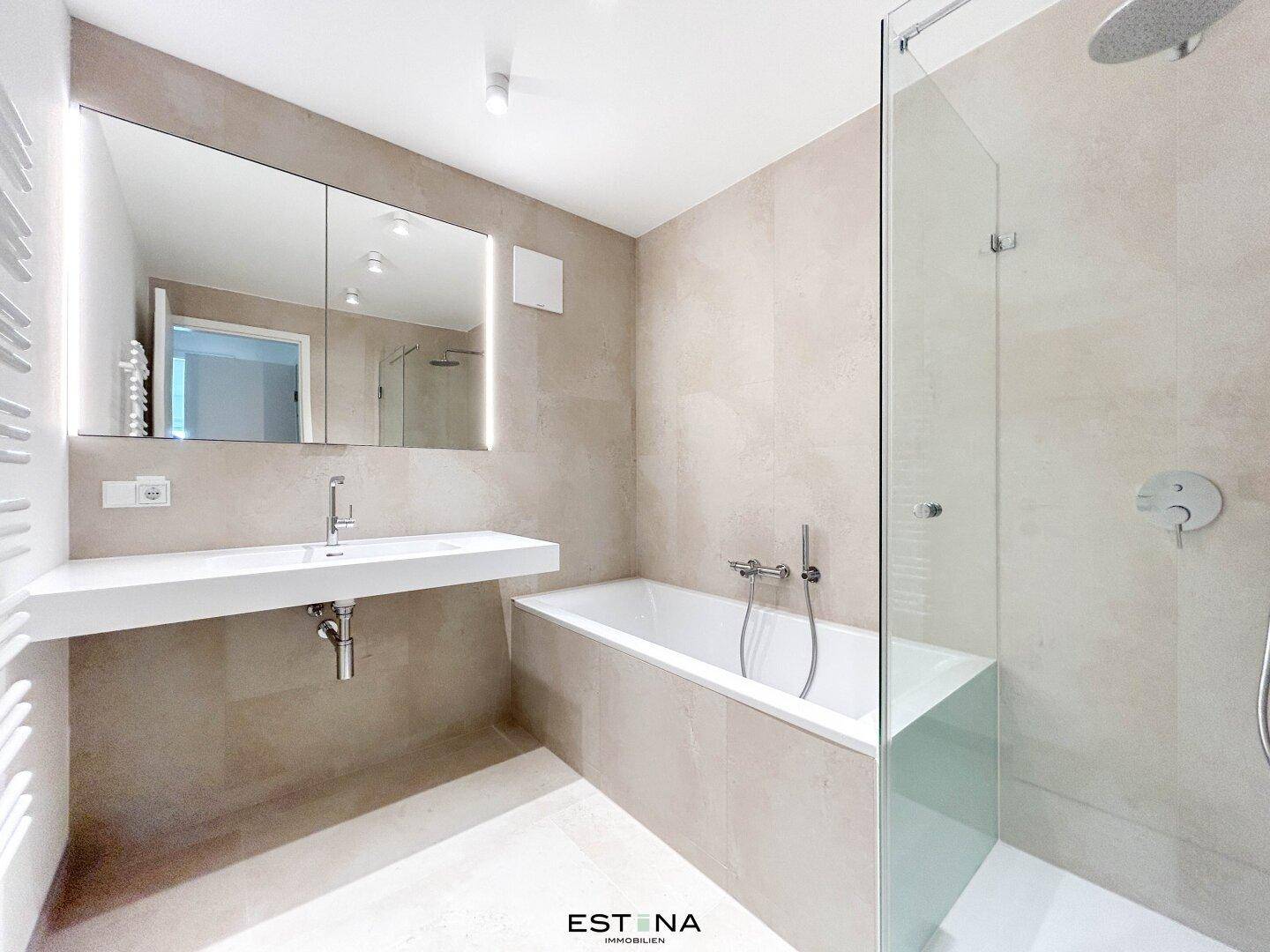 Modernes Badezimmer in hellen Beigetönen mit Badewanne, Dusche und großem Spiegelschrank über dem Waschtisch.