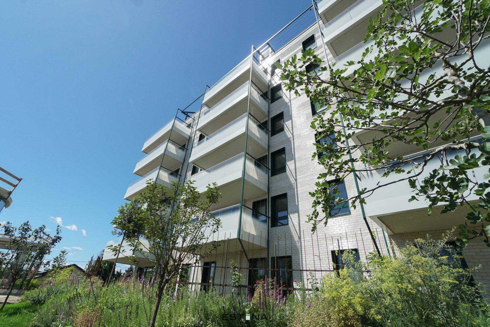 Moderne Wohnanlage mit zahlreichen Balkonen und grüner Umgebung.