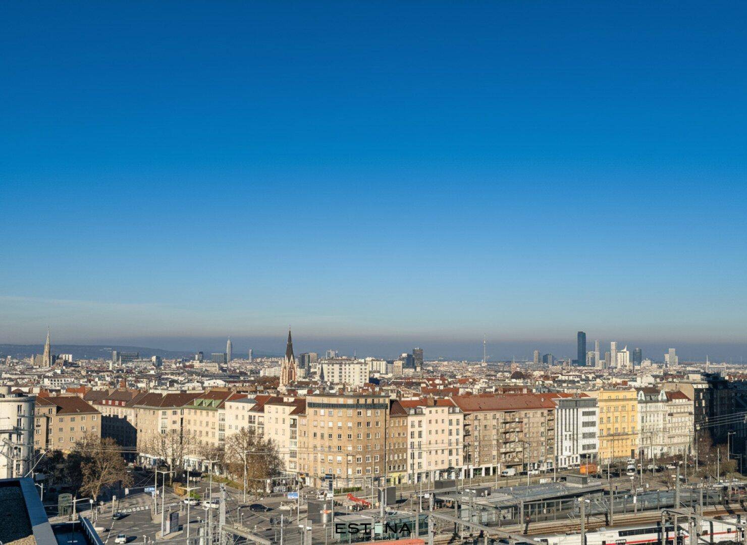 Panoramablick über die Stadt mit historischen Gebäuden und moderner Skyline unter blauem Himmel.