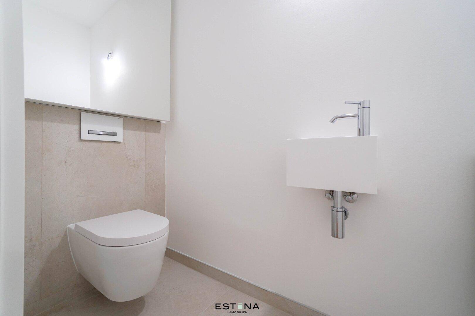 Modernes Gäste-WC mit wandhängender Toilette und kleinem Waschbecken.