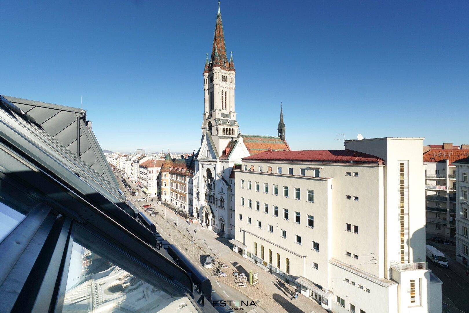 Panoramablick über die Stadt mit historischer Kirche und belebter Straße.