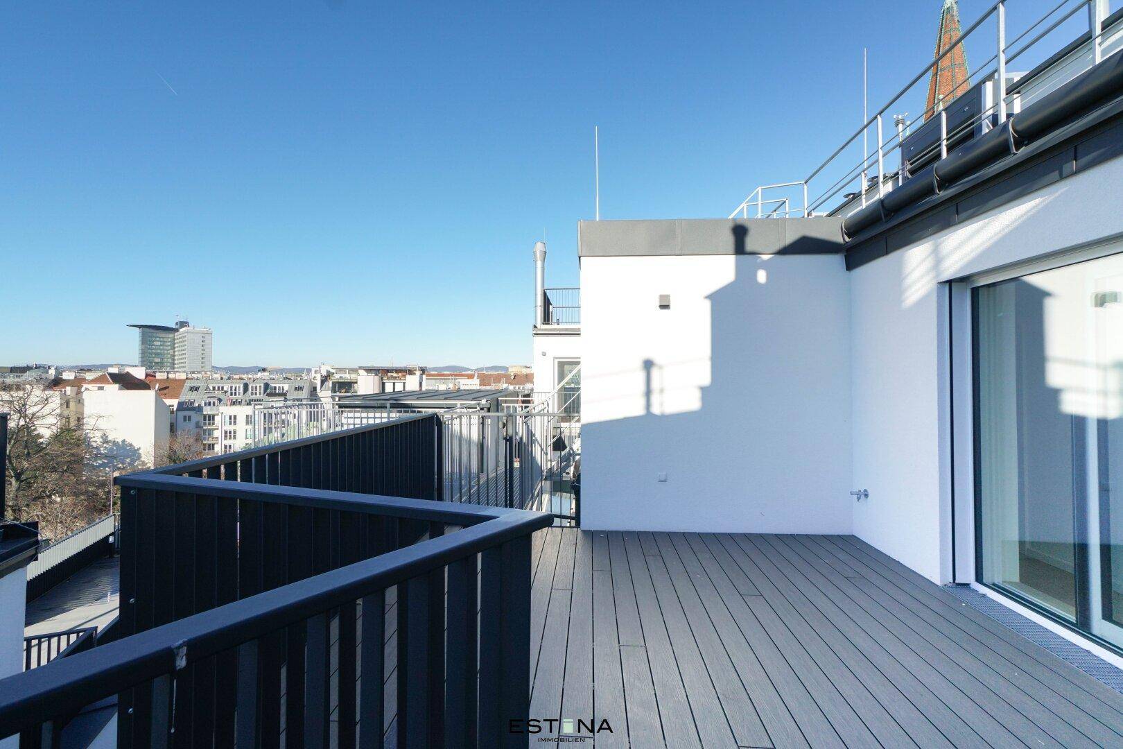 Helle Dachterrasse mit weitem Stadtblick und moderner Balustrade.