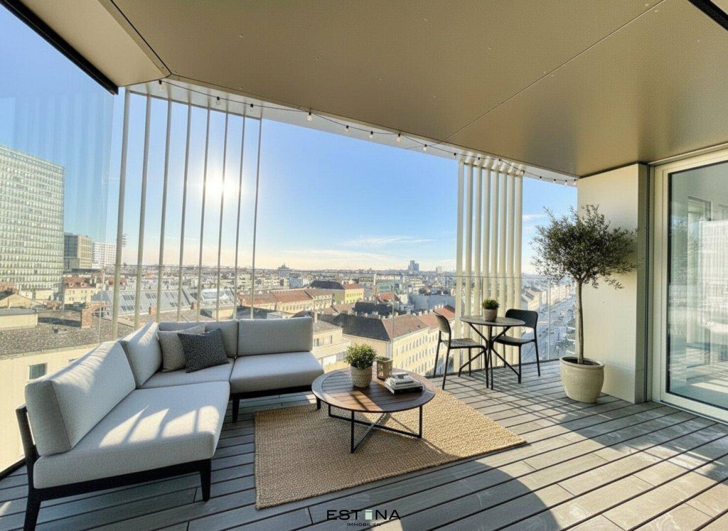 Möblierter Balkon mit bequemer Sitzecke, Pflanzen und weitem Blick über die Stadt.
