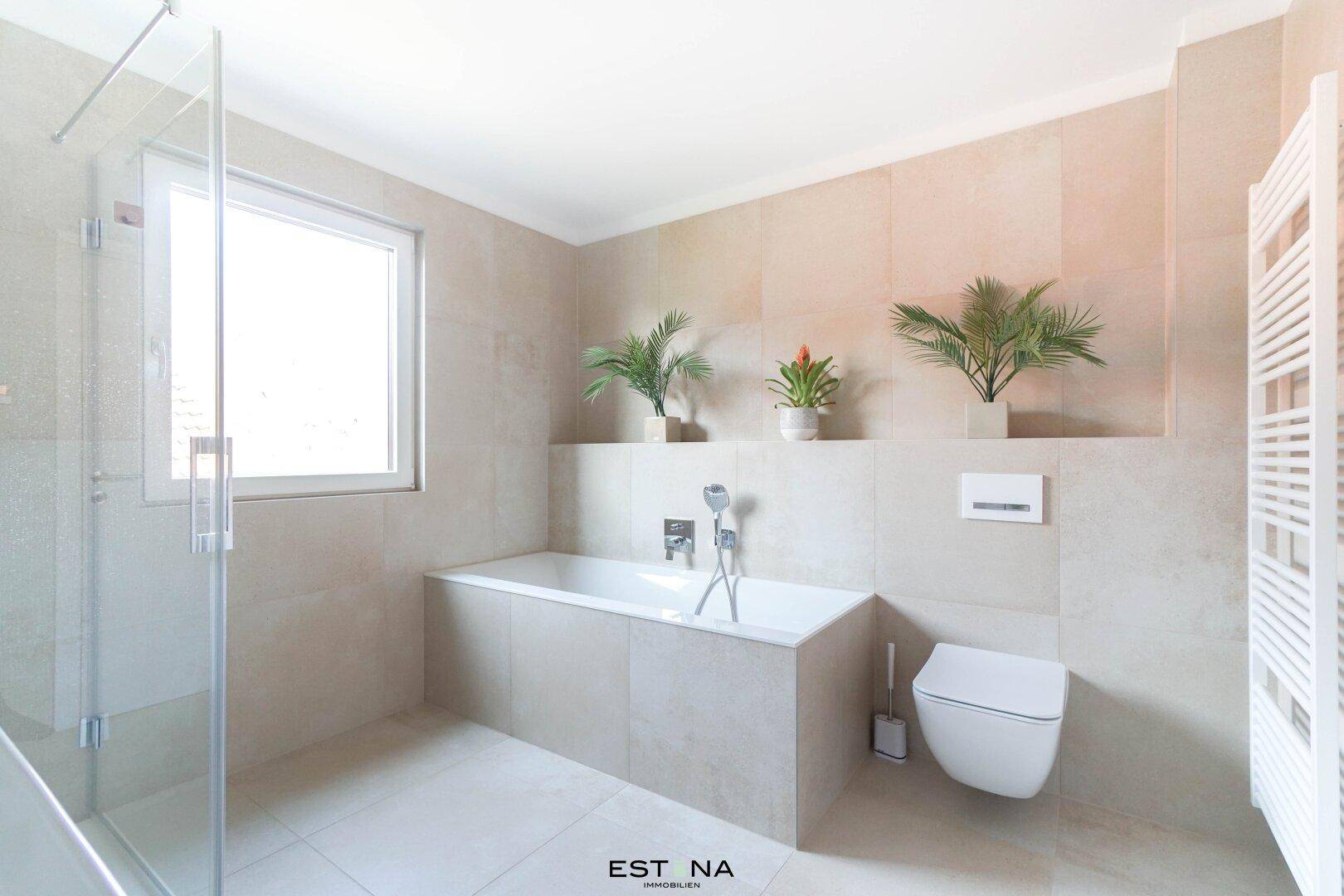 Modernes Badezimmer mit Badewanne, separater Dusche, Wand-WC und Fenster.