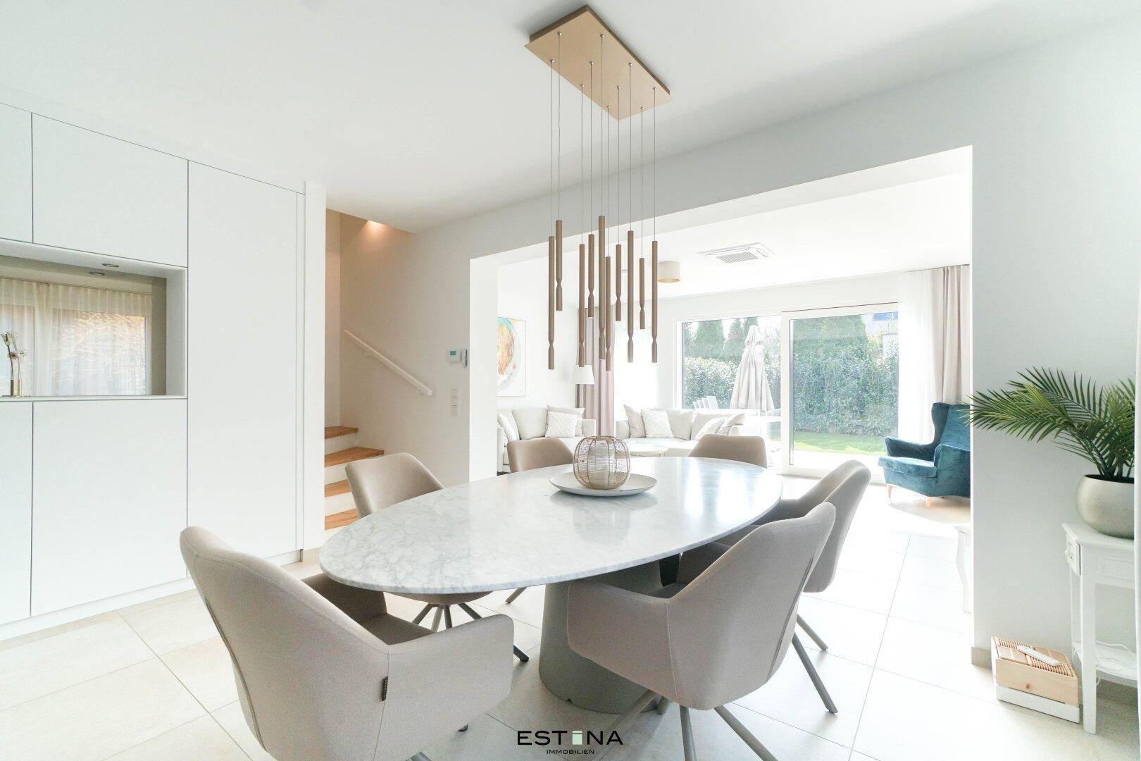 Eleganter Essbereich mit Design-Pendelleuchte und Blick in den hellen Wohnbereich.