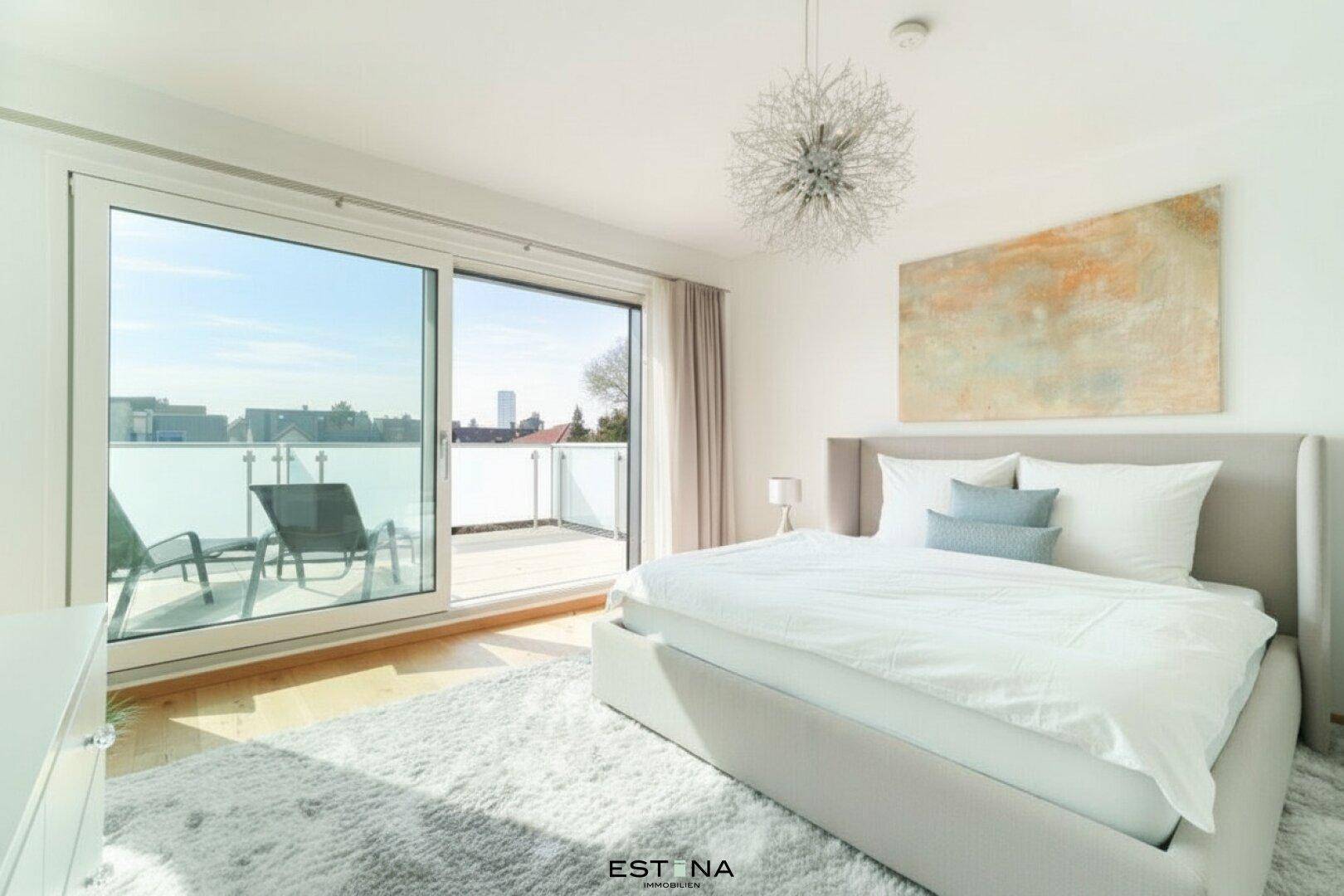 Helles Schlafzimmer mit Holzboden, großem Bett und Zugang zu einer sonnigen Dachterrasse mit Stadtblick.