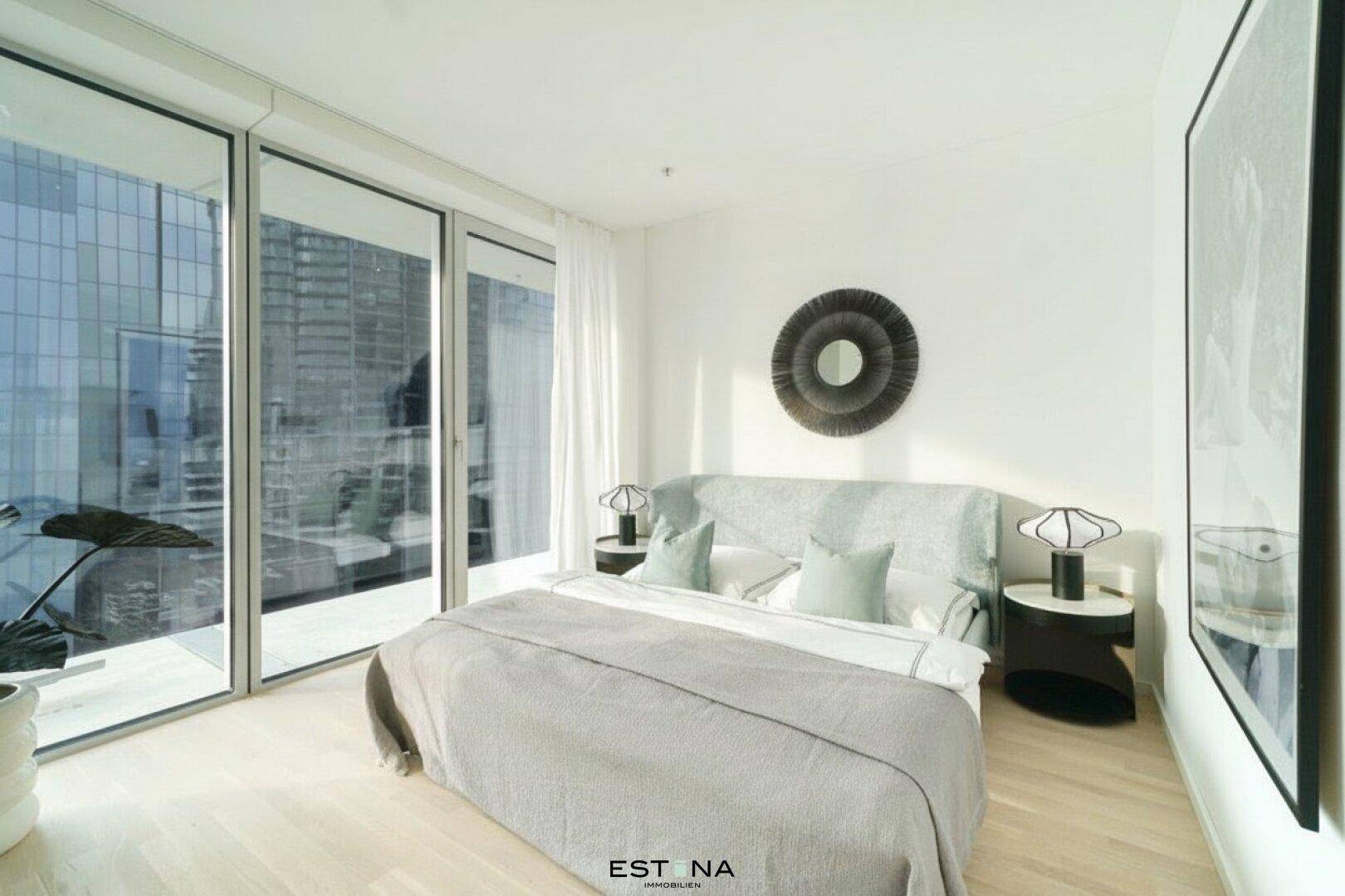 Helles Schlafzimmer mit großen Fenstern, modernem Bett und minimalistischer Einrichtung.
