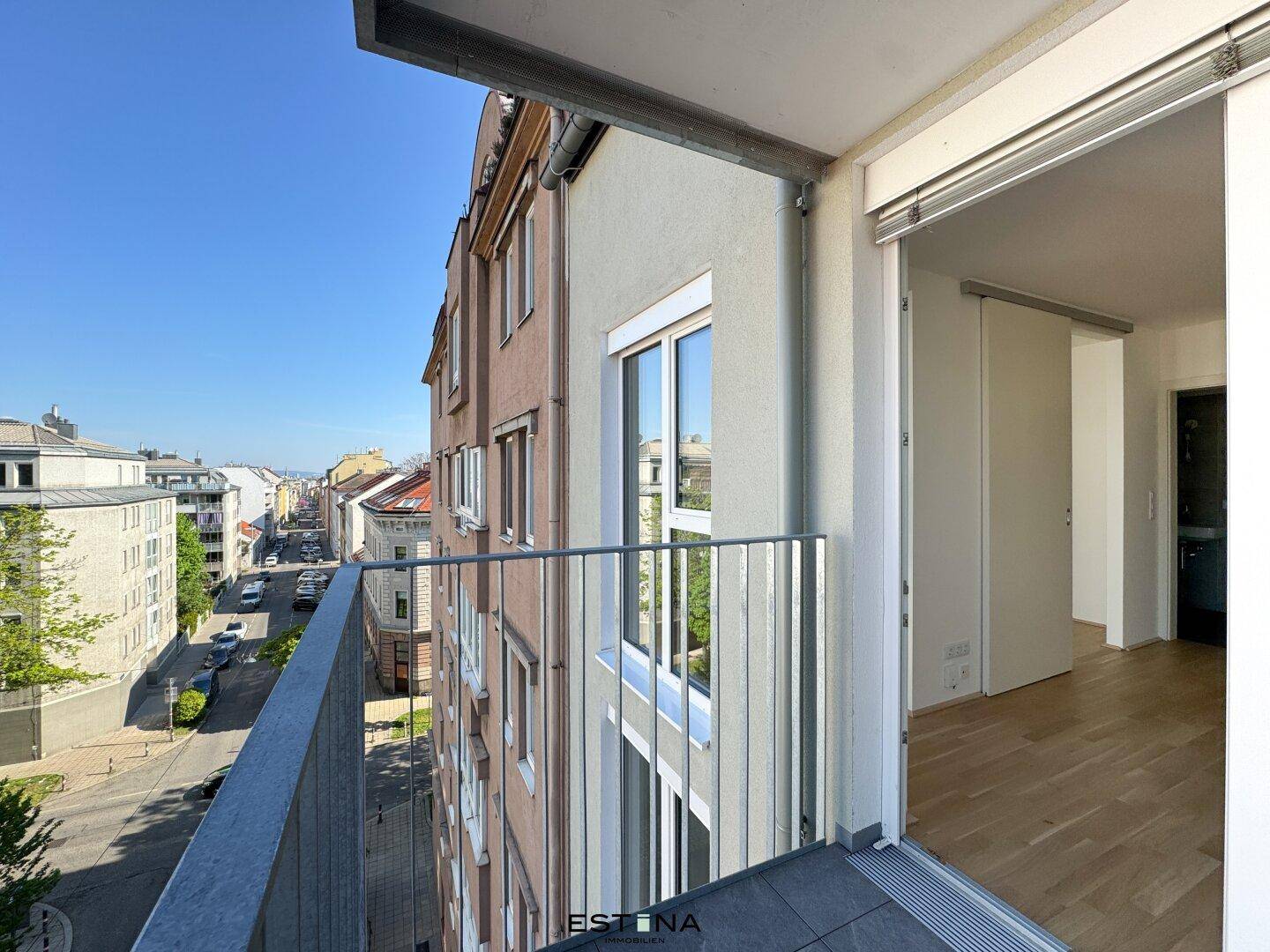 Blick vom Balkon auf die Straße und die umliegenden Gebäude der Stadt.