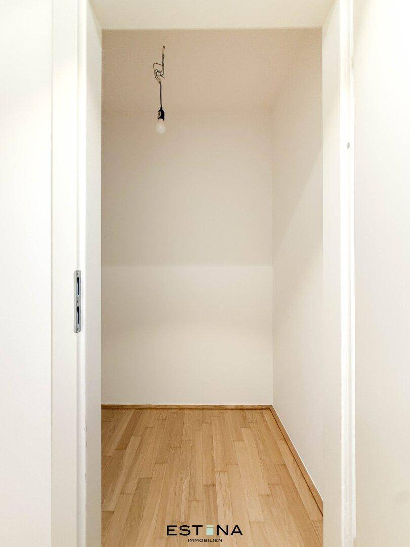 Kleiner Abstellraum mit Parkettboden und einfacher Beleuchtung, ideal für zusätzlichen Stauraum.