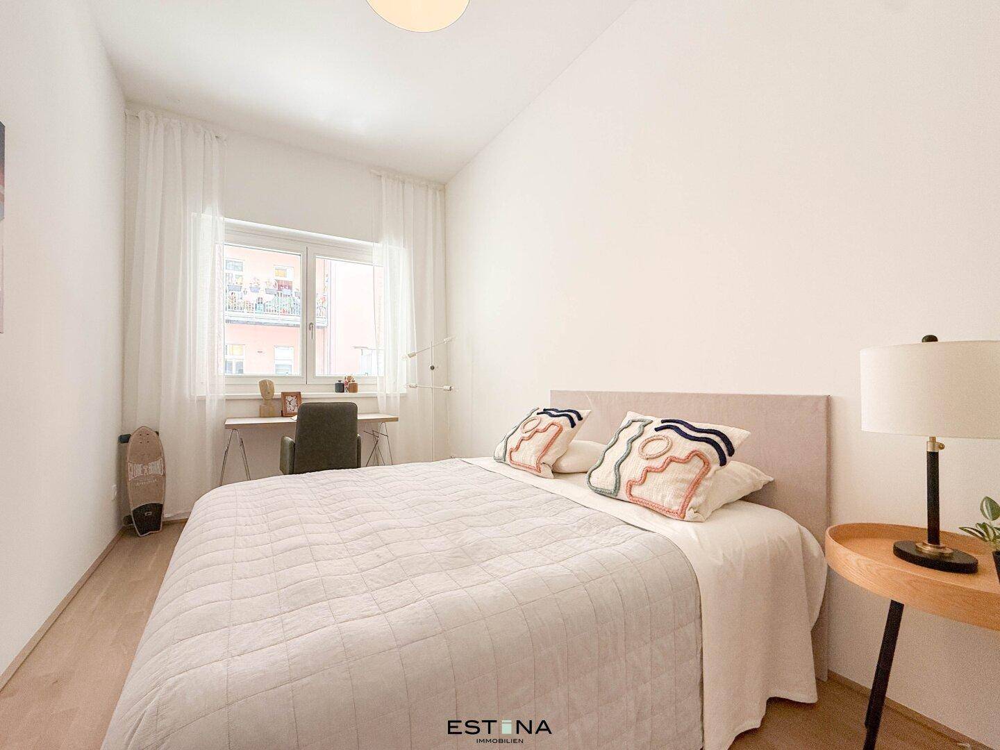 Gemütliches Schlafzimmer mit Bett, Schreibtisch und hellem Holzboden.