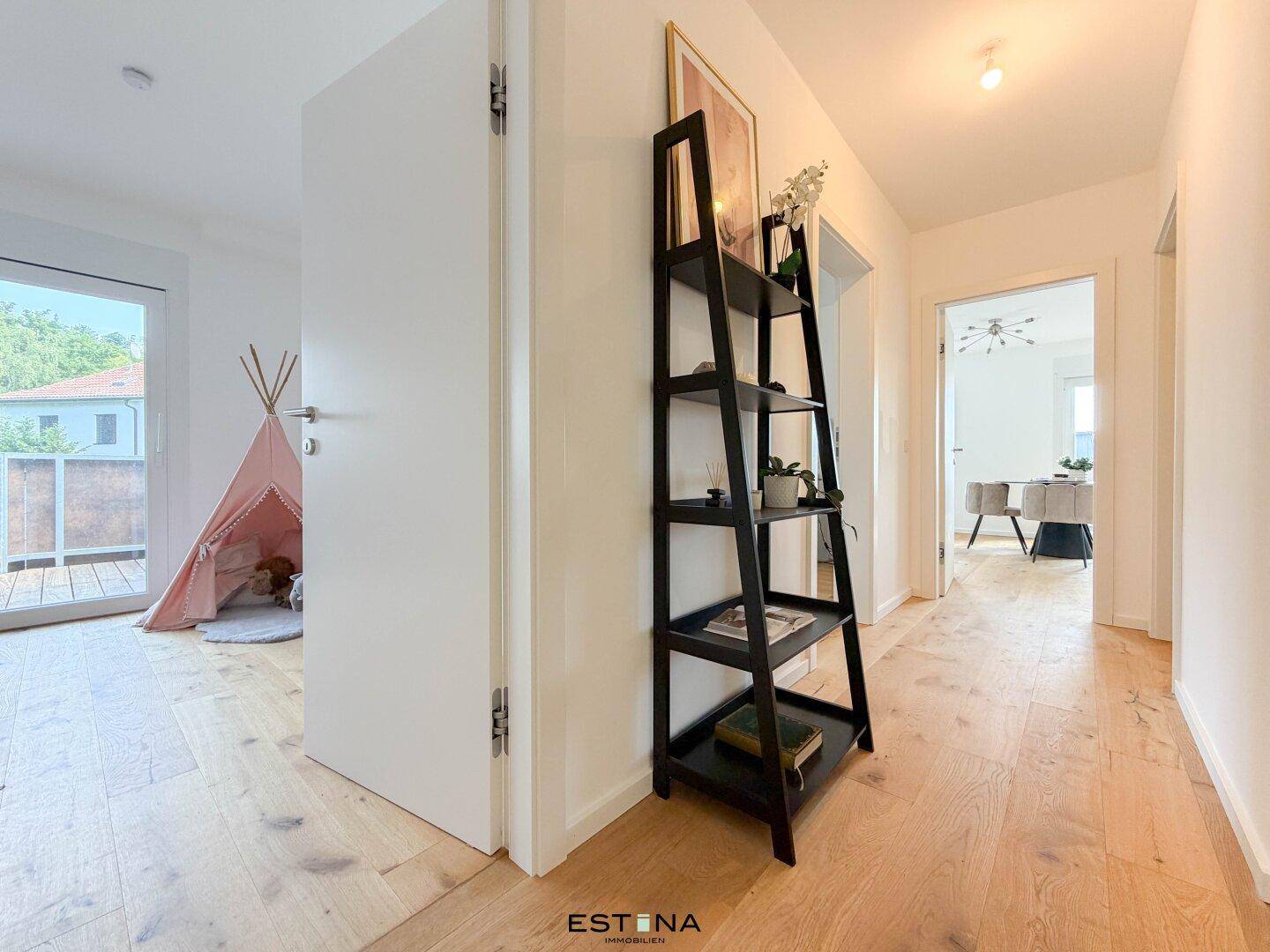 Heller Flur mit Holzboden und Zugang zu verschiedenen Räumen, inklusive Kinderzimmer mit Balkonzugang.