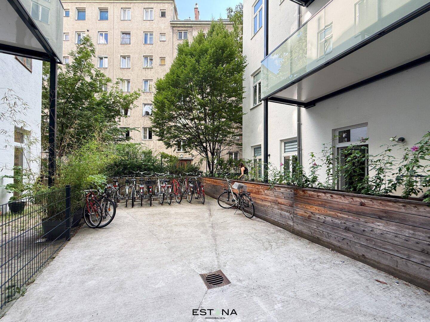 Außenbereich mit Fahrradstellplätzen und begrünten Beeten, bietet praktischen Raum im Freien.