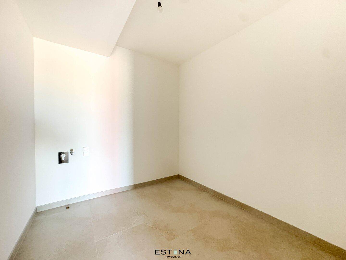 Kleiner Hauswirtschaftsraum mit Fliesenboden und Anschlüssen für Geräte.